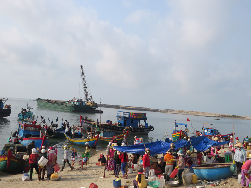Busy fishing market by seashore in the early morning
