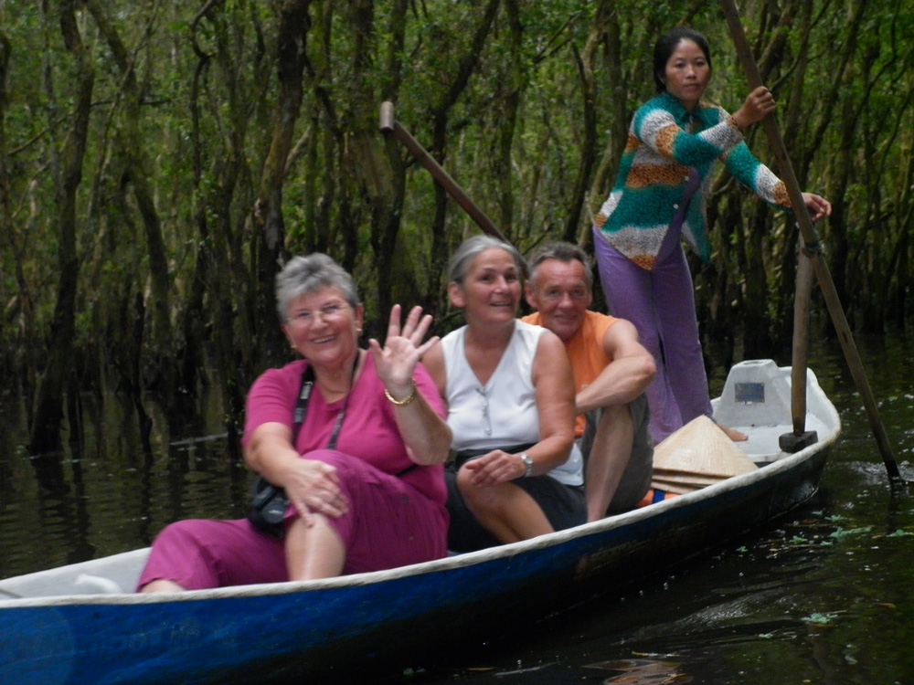 Tourists go on a boat seeing Tra Su Forest