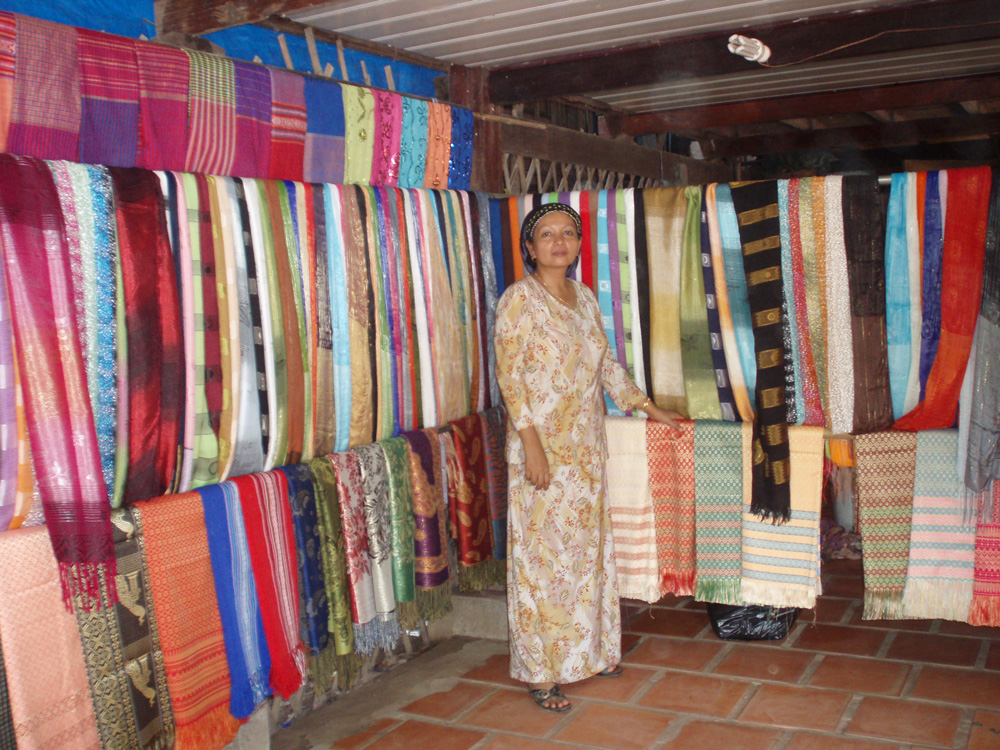 A Cham woman presenting handmade scarves